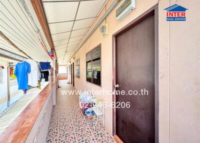 Corridor with windows and door, laundry area, and patterned floor tiles