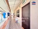 Corridor with windows and door, laundry area, and patterned floor tiles