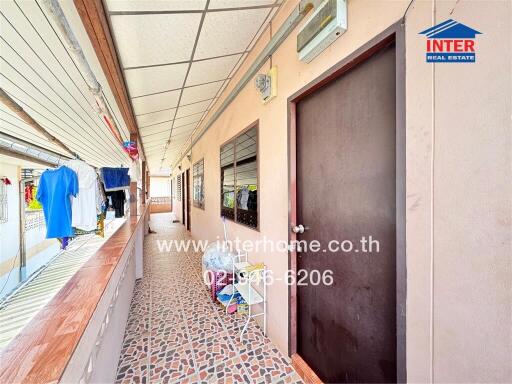 Corridor with windows and door, laundry area, and patterned floor tiles