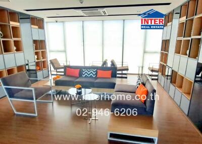 Modern living room with shelving, seating area, and large windows