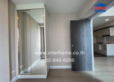 Modern bedroom with a large mirror and access to the kitchen