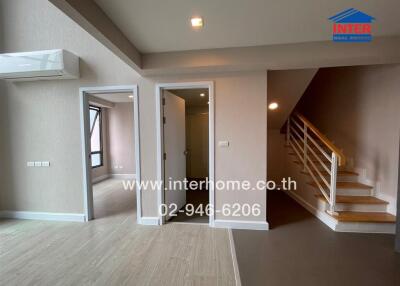 Modern living area with staircase and open doors to adjacent rooms