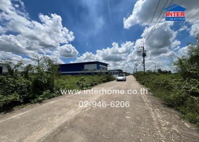 Property entrance with surrounding greenery and clear skies