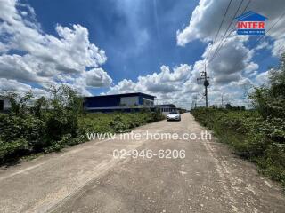 Property entrance with surrounding greenery and clear skies