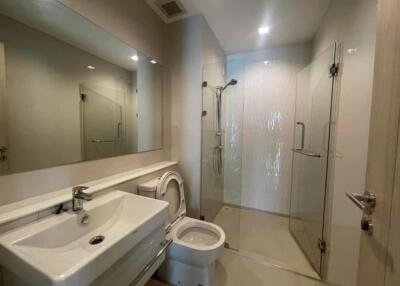 Modern bathroom with sink, toilet, and glass-enclosed shower