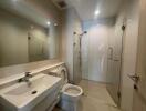 Modern bathroom with sink, toilet, and glass-enclosed shower