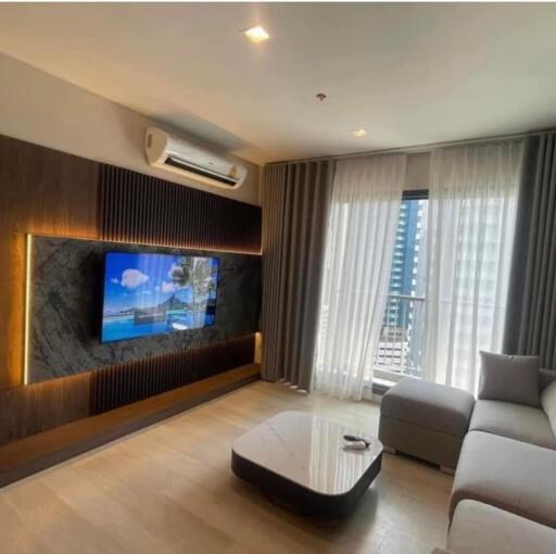 Modern living room with mounted TV and large window