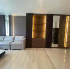 Modern living room with built-in shelving, a sofa, and wooden flooring