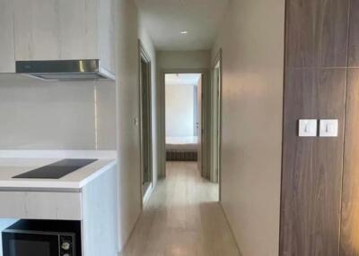 Hallway with kitchenette and view of a bedroom