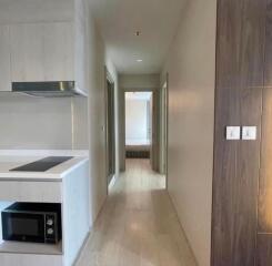 Hallway with kitchenette and view of a bedroom