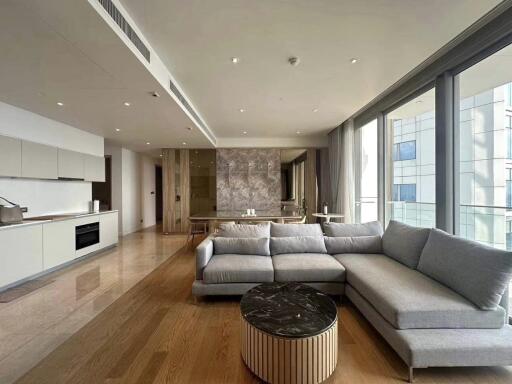 Modern living room with an open kitchen and a large gray sofa