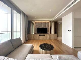 Modern living room with gray sofa, TV, and wooden flooring