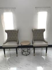 Two elegant chairs with a small table between them in a bright living area