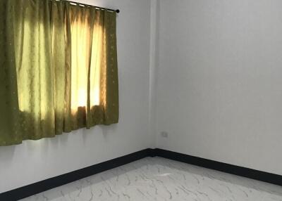 Empty bedroom with tiled floor and green curtains