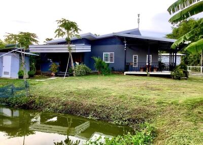 Modern house with a large yard next to a pond