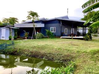 Modern house with a large yard next to a pond