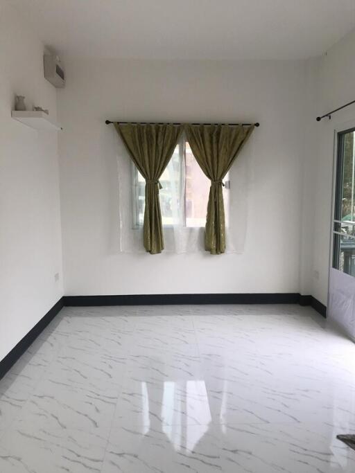 Bright and empty living room with marble floor and green curtains