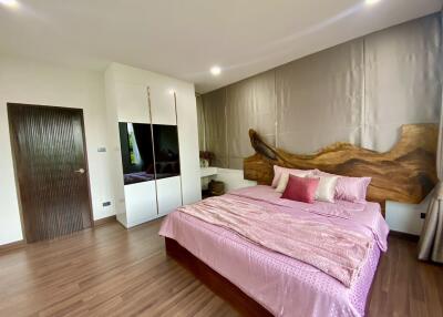 Spacious bedroom with pink bedding and wooden accents