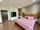 Spacious bedroom with pink bedding and wooden accents