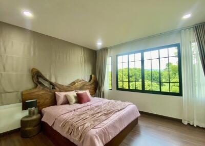 Spacious bedroom with large windows and scenic view