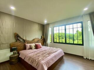 Spacious bedroom with large windows and scenic view