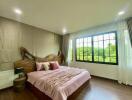 Spacious bedroom with large windows and scenic view