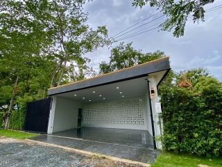 Modern garage with a flat roof and surrounding greenery