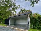 Modern garage with a flat roof and surrounding greenery