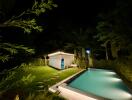 Night view of the backyard with a pool and a shed