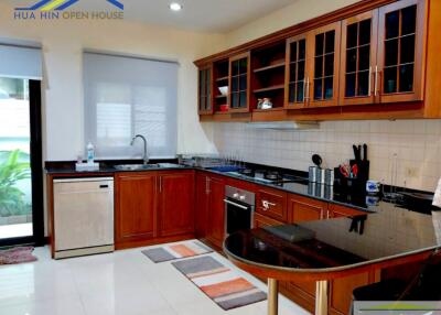 Modern kitchen with wooden cabinets and black countertops