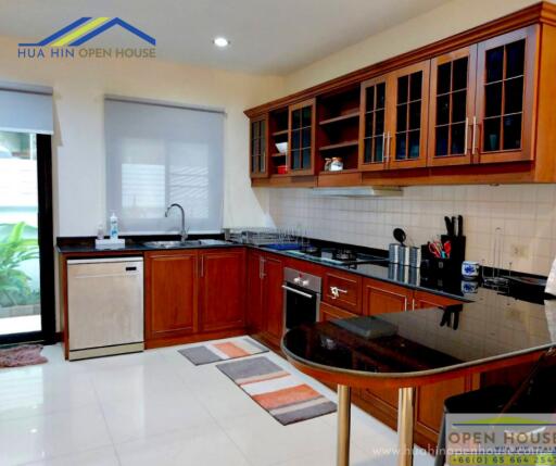 Modern kitchen with wooden cabinets and black countertops