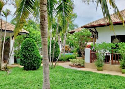 Lush garden with tropical plants and villa houses