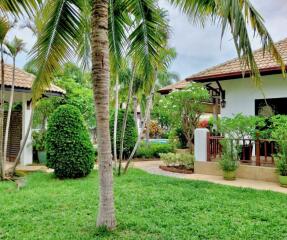 Lush garden with tropical plants and villa houses