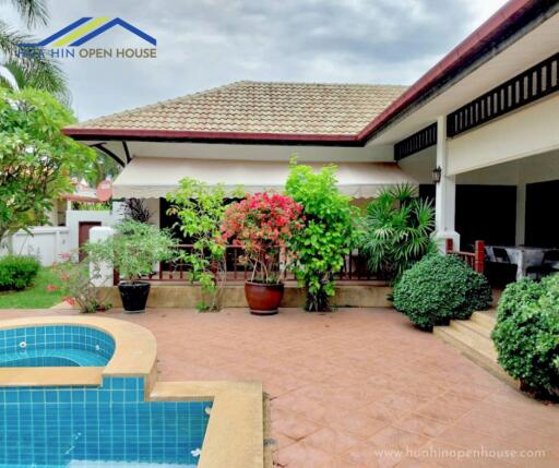 Outdoor view of a house with a pool and greenery