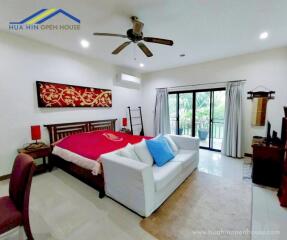 Spacious bedroom with double bed, sofa, and balcony access