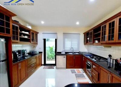 Spacious modern kitchen with wooden cabinets and black countertops