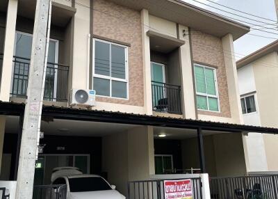 Front view of a modern townhouse with carport and balconies