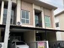 Front view of a modern townhouse with carport and balconies