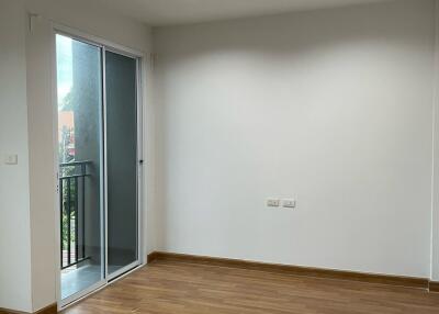 Unfurnished bedroom with wood flooring and balcony access