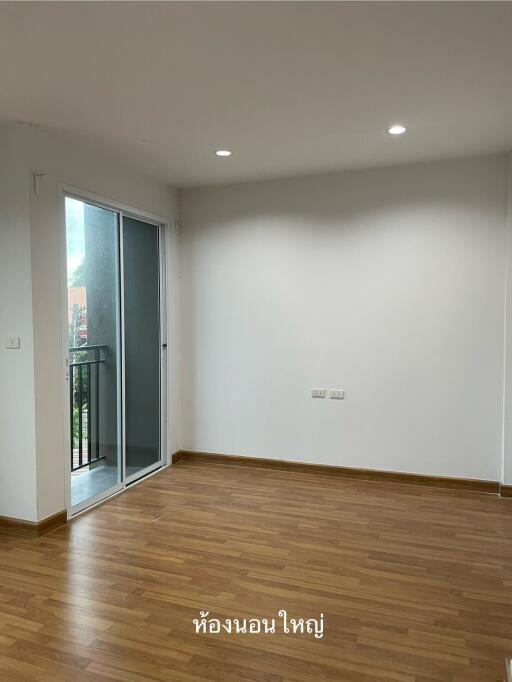 Unfurnished bedroom with wood flooring and balcony access