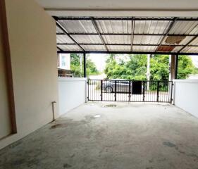 Open garage space with a metal roof and front gate