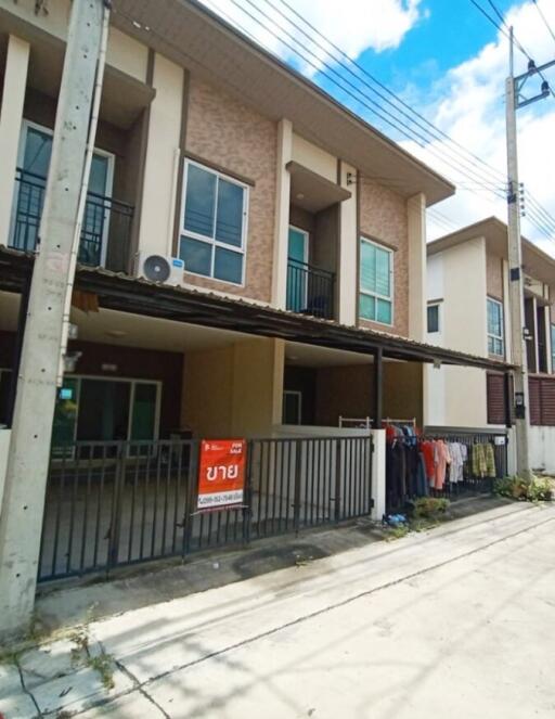 Two-story modern townhouse with a small front yard and parking space.