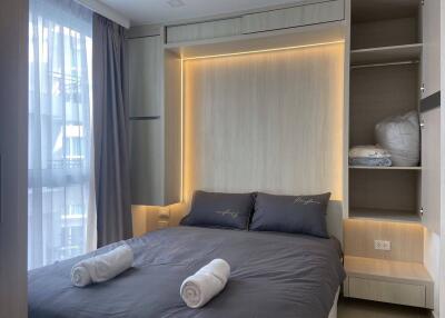 Modern bedroom with double bed, built-in wardrobe, and large window