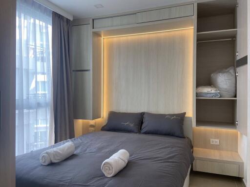 Modern bedroom with double bed, built-in wardrobe, and large window