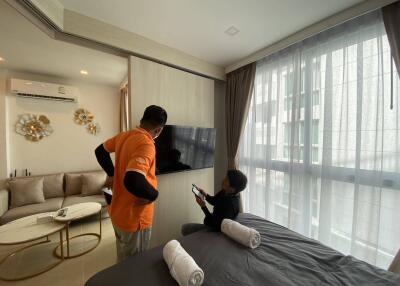 People in a modern bedroom with a TV on the wall