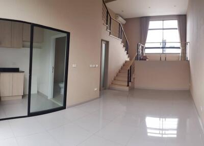 Spacious living area with high ceiling and staircase to second level