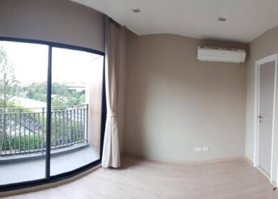 Bright bedroom with large glass doors leading to a balcony