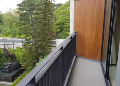 Balcony with black railing and view of garden