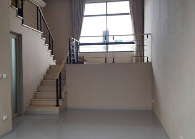 Spacious living area with staircase and large window