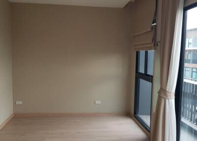 Empty bedroom with large window and curtains